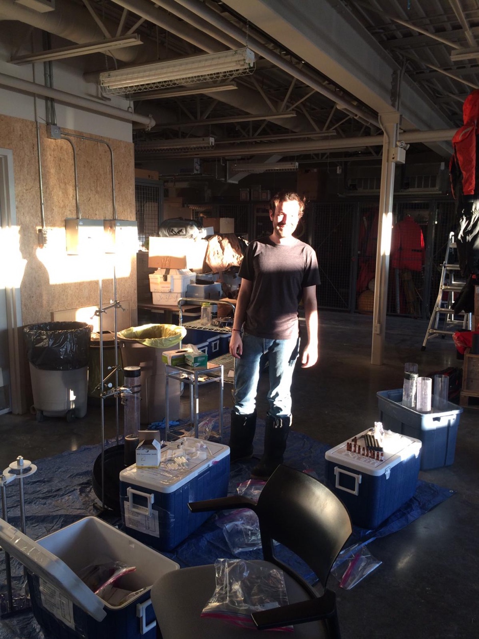 Thomas Bossé-Demers working in the loading bay at ARI under the warm rays of the midnight sun, collecting pore water from the sediment cores sampled in the Mackenzie Delta, Northwest Territories, April 24, 2019. ©Marine Béguin Takuvik2019 Picture5 7 web