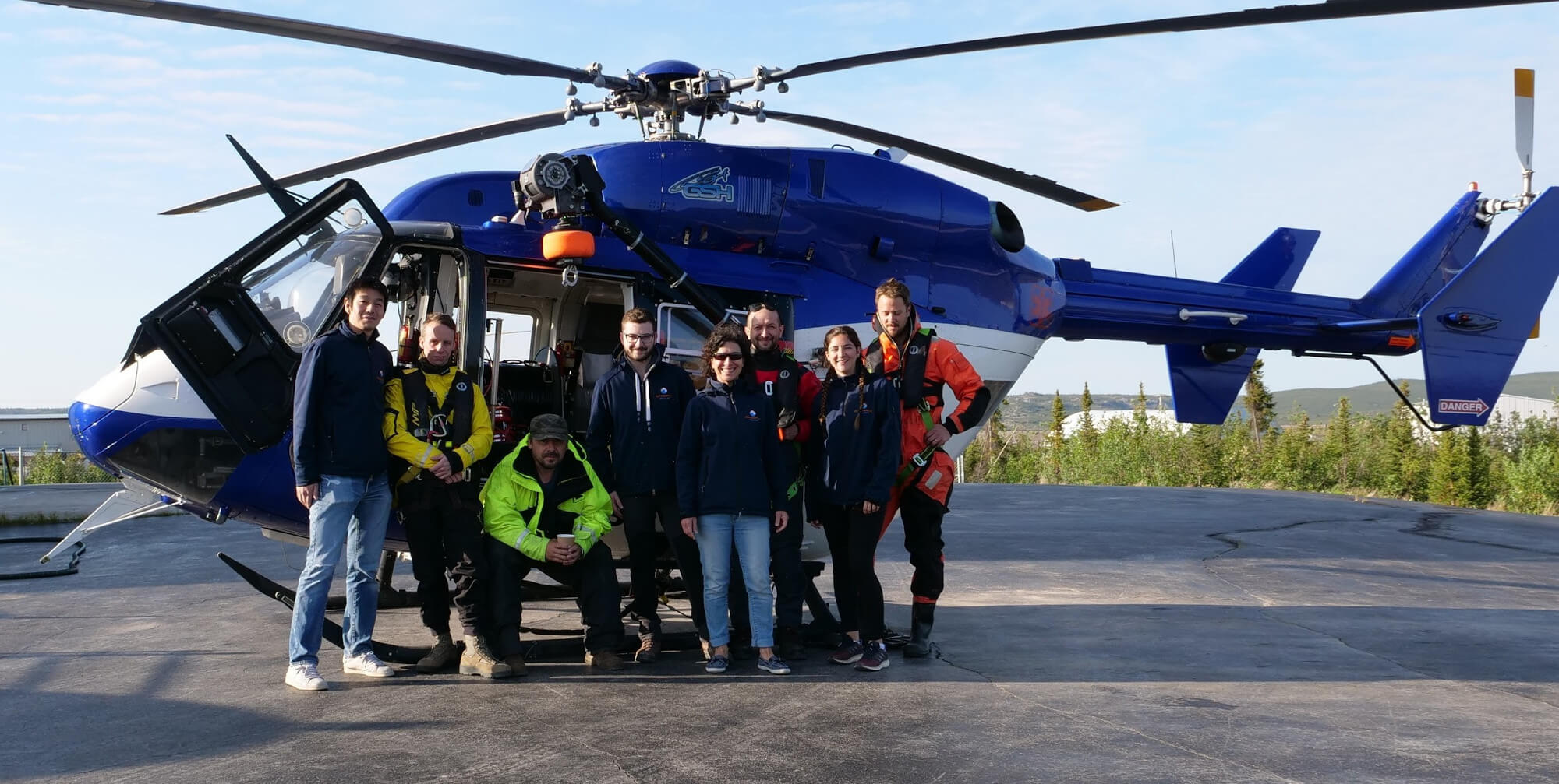 The whole expedition team (Atsushi Matsuoka, Tim Baker, Dan Munteanu, Lucas Tisserand, Caroline Guilmette, Guislain Bécu, Juliette Maury & Bennet Juhls) in front of the BK117 helicopter at the GSH base in Inuvik. © Takuvik Lab Takuvik2019 Picture7 4