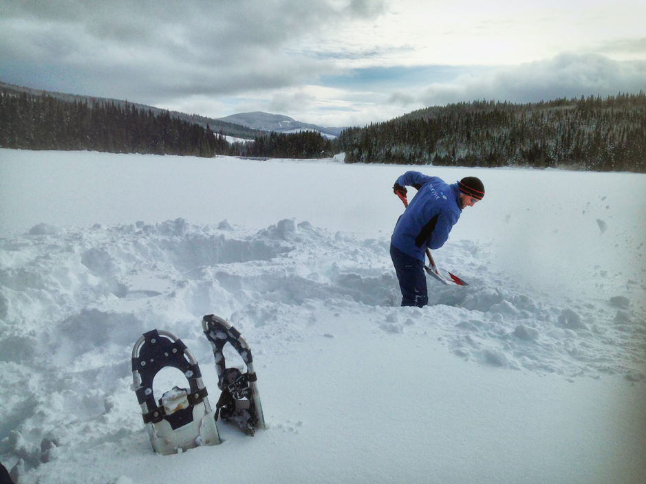 Guislain Bécu shovels snow to uncover the slushy surface of the ice over Piché Lake, Forêt Montmorency, Canada, February 4, 2019. ©Béatrice Saint-Cricq. Takuvik spring prep 2019 M.Lizotte Picture4