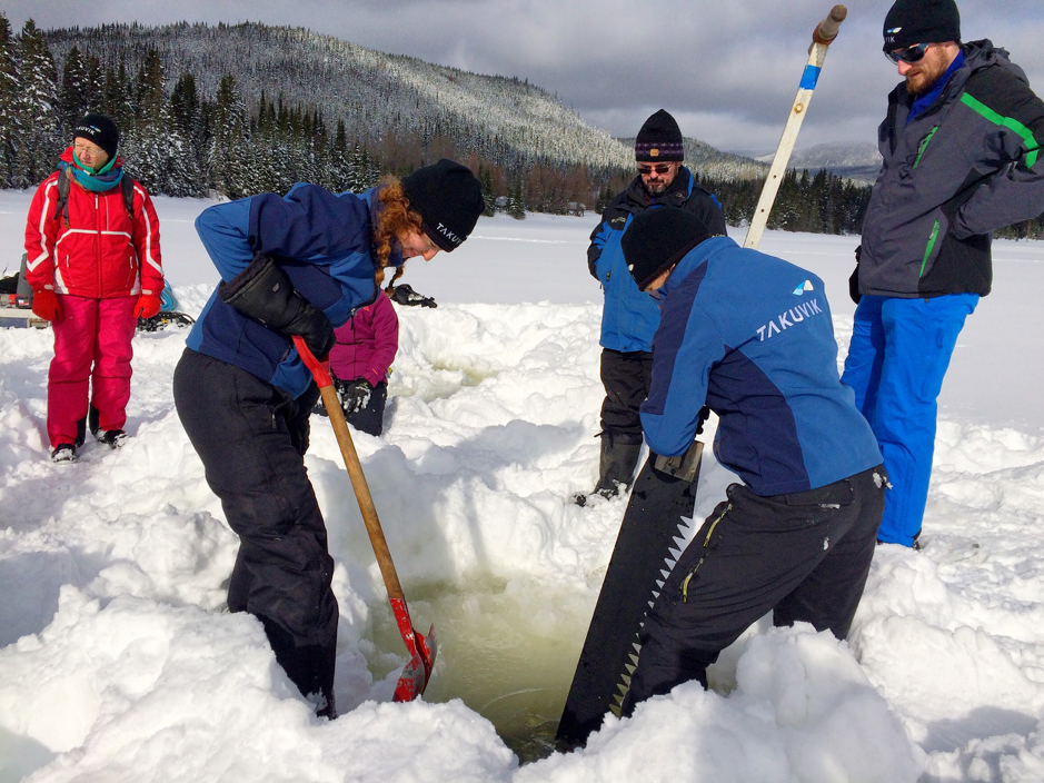 Martine Lizotte shovels slush out of the auger hole while Joannie Ferland cuts through the ice with a large ice saw, Piché Lake, Forêt Montmorency, Canada, February 4, 2019. Also on this picture Béatrice Saint-Cricq (left), Marie-Hélène Forget (kneeling), Sylvain Blondeau and Christian Katlein (right). ©Caroline Guilmette. Takuvik spring prep 2019 M.Lizotte Picture5